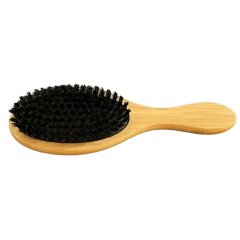 A wooden brush with black bristles on top of green background.